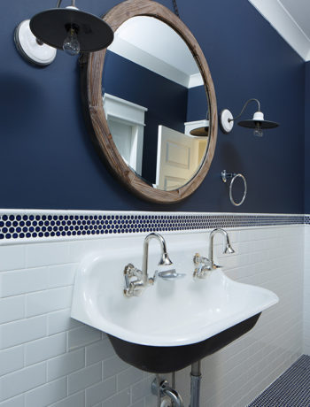 Navy and white bathroom with round mirror